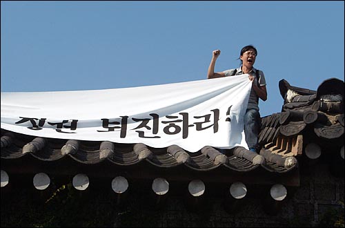 광화문에 올라가서 기습시위를 벌이며 구호를 외치는 시위대. 